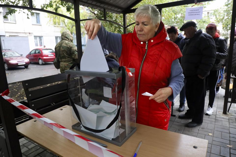 Una mujer deposita su voto durante un referéndum en una casilla electoral móvil el viernes 23 de septiembre de 2022, en Mariúpol, en la región ucraniana de Donetsk, controlada por separatistas respaldados por Rusia. (AP Foto)