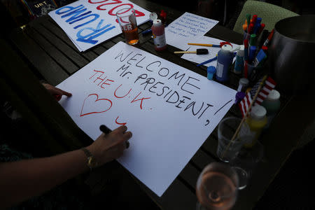 An attendee writes a placard ahead the visit to the United Kingdom of Donald Trump the President of the United States at a Republicans Overseas event in London, Britain, July 4, 2018. REUTERS/Simon Dawson