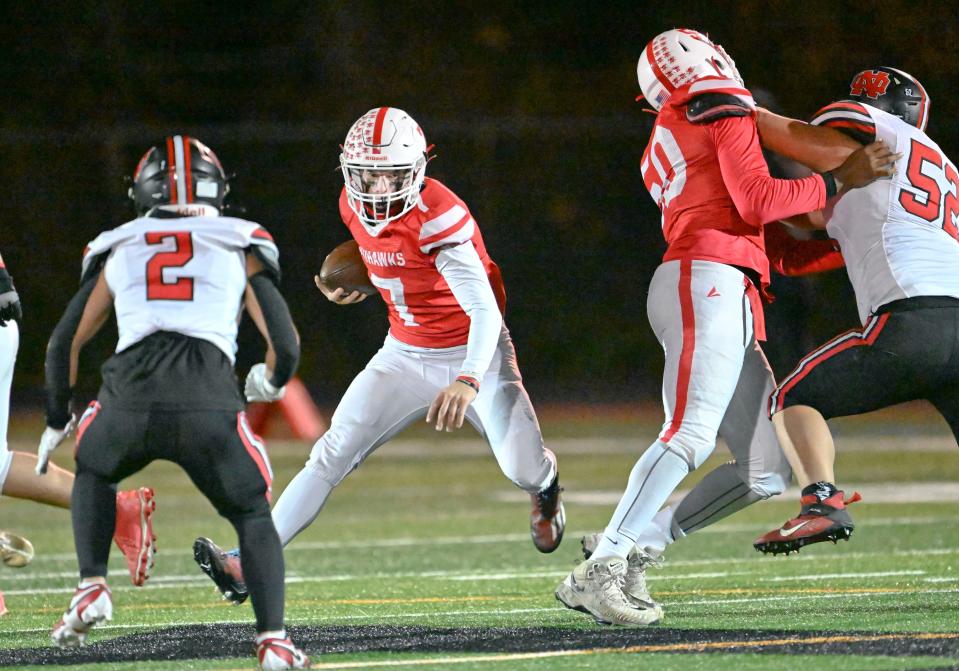 Barnstable quarterback Aiden Kundel follows the block of Ronell Armstrong on Alan Guan of North Quincy