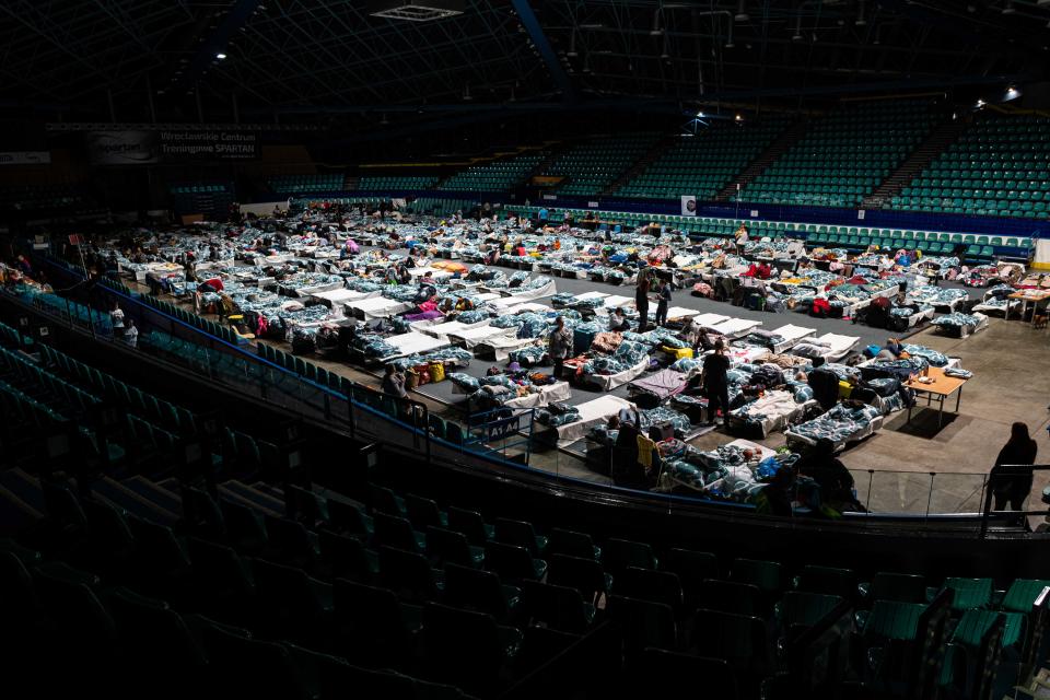 Refugees from Ukraine crowd together at a reception point in a sports hall in Wroclaw, Poland.