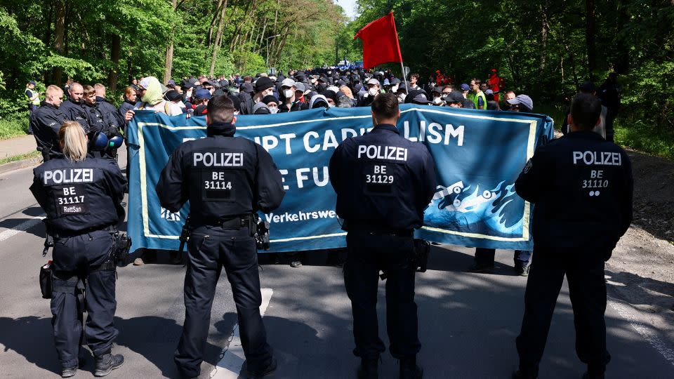 Police officers stand in front of activists protesting against the expansion of the Tesla factory near Berlin, Germany on May 10, 2024. - Christian Mang/Reuters