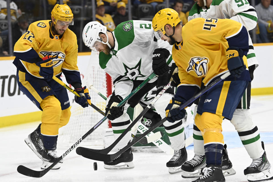 Dallas Stars defenseman Jani Hakanpaa (2) battles for the puck between Nashville Predators right wing Nino Niederreiter (22) and defenseman Alexandre Carrier (45) during the second period of an NHL hockey game Thursday, Oct. 13, 2022, in Nashville, Tenn. (AP Photo/Mark Zaleski)