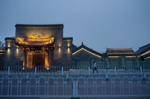 A man walks by the newly built "heritage" buildings in Beijing's historical Qianmen street. Beijing has announced plans to rebuild some of the gates in its long-lost imperial city wall, but in China, conservation often means demolition