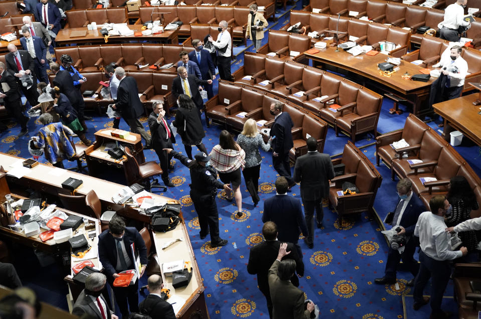 WASHINGTON, DC - JANUARY 06: Members of Congress evacuate the House Chamber as protesters attempt to enter during a joint session of Congress on January 06, 2021 in Washington, DC. Congress held a joint session today to ratify President-elect Joe Biden's 306-232 Electoral College win over President Donald Trump. A group of Republican senators said they would reject the Electoral College votes of several states unless Congress appointed a commission to audit the election results. Pro-Trump protesters entered the U.S. Capitol building after mass demonstrations in the nation's capital. (Photo by Drew Angerer/Getty Images)