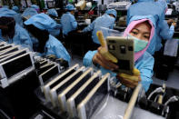 A worker holds an OPPO F1S smartphone at an OPPO smartphone factory in Tangerang, Indonesia, September 20, 2016. REUTERS/Beawiharta