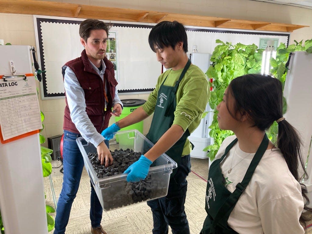 Tyler Foote,(left) an agribusiness teacher at Vincent High School, gets assistance from Theodore Her, 17,(center) and Ab Sheng Xiong, 17, maintaining one of the 12 hydroponics Flex Farm purchased through a $300,000 USDA grant in the school's newly created "Grow Room."