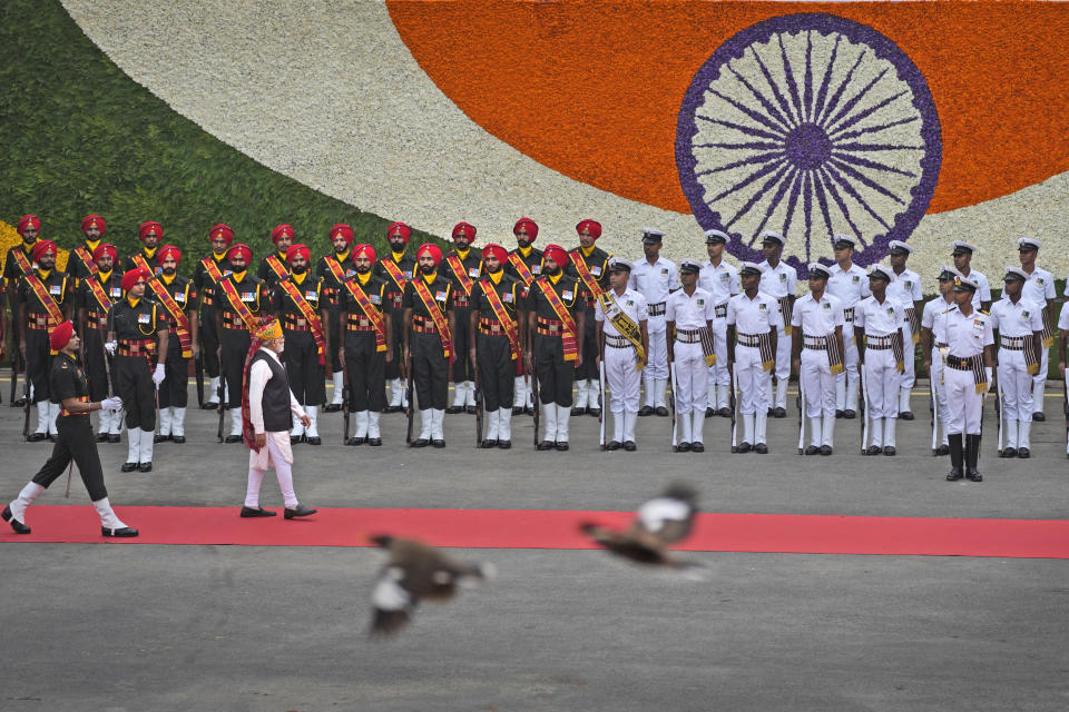 Birds fly past as Indian Prime Minister Narendra Modi inspects a joint military guard of honor at 17th century Mughal-era Red Fort monument on country's Independence Day in New Delhi, India, Tuesday, Aug.15, 2023. Modi promised to take India's economy into the top three in the world in the next five years, as he marked 76 years of independence from British rule on Tuesday. (AP Photo/Manish Swarup)