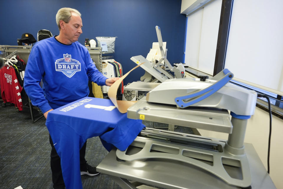 Brent Kisha, STAHLS' vice president of strategic sales, demonstrates using a Hotronix Fusion IQ heat press to put a name on shirt in St. Clair Shores, Mich., Monday, April 22, 2024. STAHLS' rapidly personalizes jerseys for each first-round pick as they are announced at the NFL draft. (AP Photo/Paul Sancya)