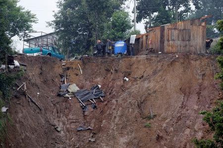 Residents stand outside their damaged houses after a mudslide following heavy showers caused by the passing of Tropical Storm Earl, in the town of Huauchinango, in Puebla state, Mexico, August 7, 2016. REUTERS/Stringer