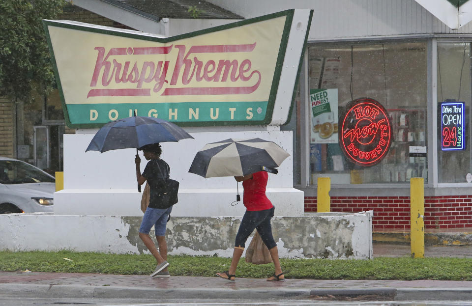 Two woman covered from the rain with umbrellas as they walk in Miami as Tropical Storm Gordon pass by South Florida with wind gust and heavy rainfall for the Labor Day holiday on Monday, Sept. 3, 2018. (David Santiago/Miami Herald via AP)