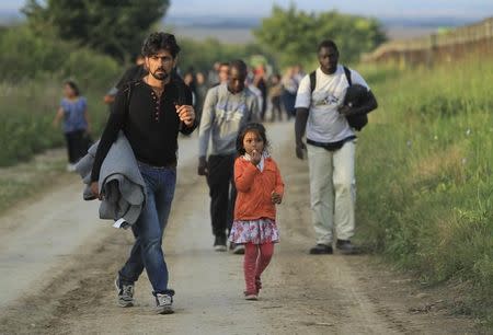 A group of migrants walk on the Serbian side of the border near Sid, Croatia September 16, 2015. REUTERS/Antonio Bronic