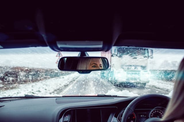 Woman driving car in snow