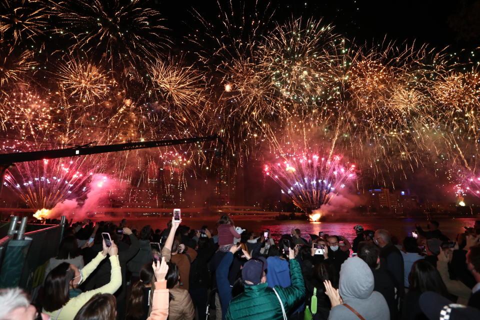 People celebrate in Brisbane, Australia, Wednesday, July 21, 2021, following an announcement by the International Olympic Committee that Brisbane was picked to host the 2032 Olympics. The Australian city was the inevitable winner of a one-candidate race steered by the IOC to avoid rival bids. (Jason O'Brien/AAP Image via AP)