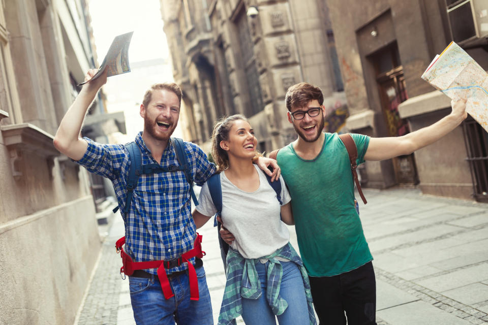 Three friends smiling and walking down the street