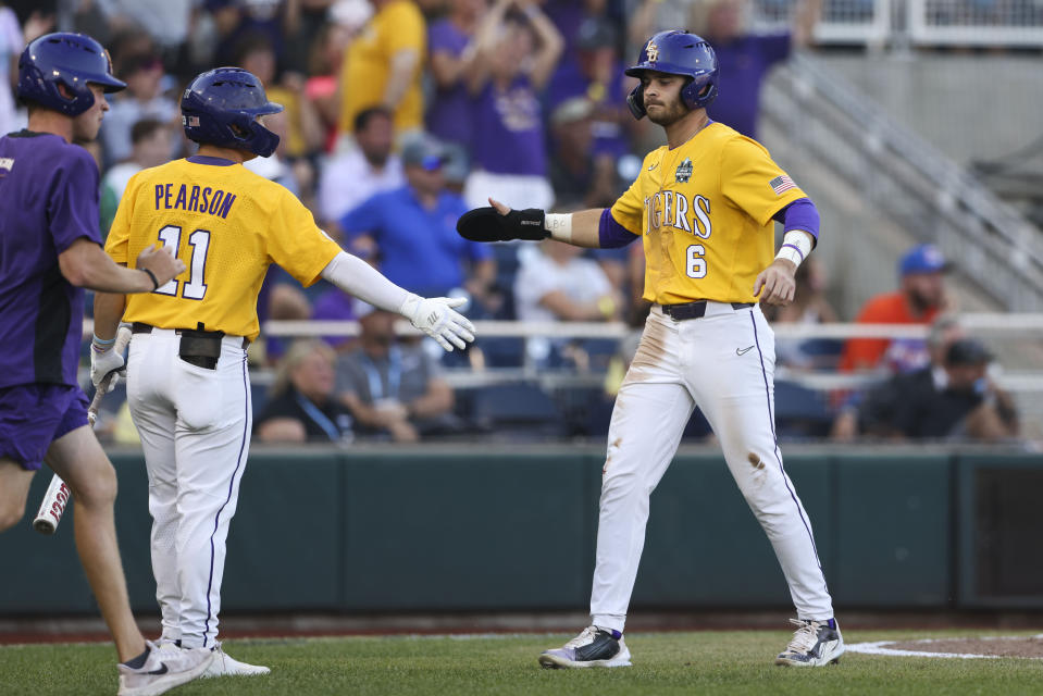 LSU's Brayden Jobert (6) celebrates with Josh Pearson (11) after scoring on an RBI double by Jordan Thompson in the fourth inning of Game 3 of the NCAA College World Series baseball finals against Florida in Omaha, Neb., Monday, June 26, 2023. (AP Photo/Rebecca S. Gratz)