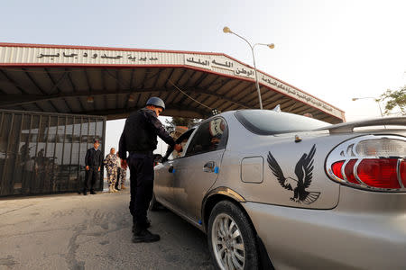 A Jordanian policeman checks a car at Jordan's Jaber border crossing checkpoint near Syria's Nasib checkpoint, near Mafraq, Jordan, October 15, 2018. REUTERS/Muhammad Hamed