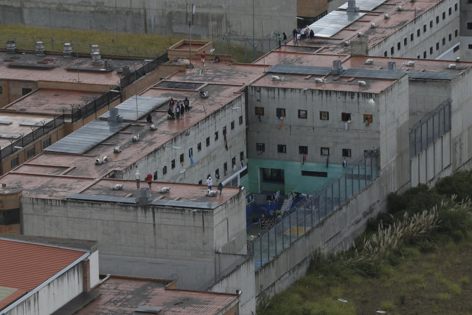Prisoners stand on the roof of the Turi jail where dozens of prison guards and police officers have been kidnapped by the inmates, in Cuenca, Ecuador, Thursday, Aug.31, 2023. In the last 24 hours, Ecuador has been rocked by the explosions of four car bombs and the hostage-taking of more than 50 law enforcement officers inside various detention facilities. (AP Photo/Xavier Caivinagua)