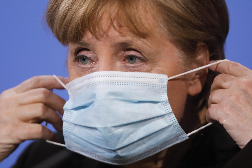 FILE-In this March 30, 2021 taken photo German Chancellor Angela Merkel puts on her face mask after she briefs the media following a virtual meeting with federal state governors at the chancellery in Berlin, Germany. Chancellor Angela Merkel has urged Germans to accept nationwide pandemic restrictions that came into force at midnight, resulting in nighttime curfews, further limits on personal contacts and access to non-essential stores in regions with high infection rates. (AP Photo/Markus Schreiber)