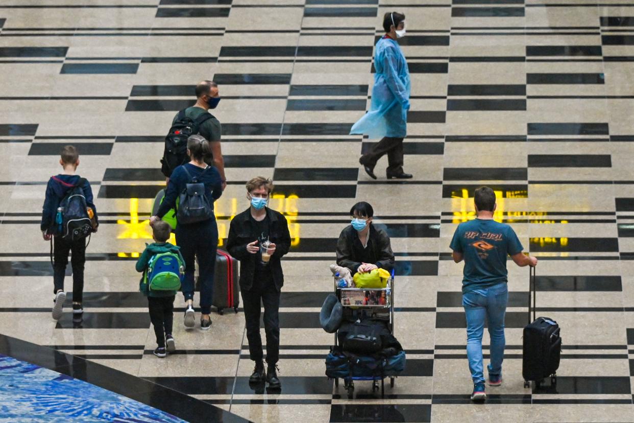 Travellers walk through the transit hall at Changi International Airport in Singapore on December 2, 2021. / AFP / Roslan RAHMAN