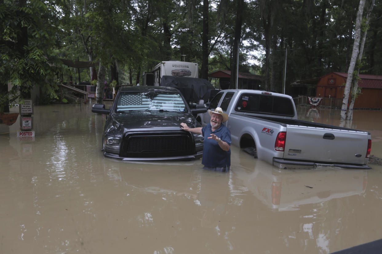 A man waves at Texas Parks & Wildlife Department game wardens as they arrive by boat to rescue residents from floodwaters in Liberty County, Texas, on Saturday, May 4, 2024. / Credit: Lekan Oyekanmi / AP
