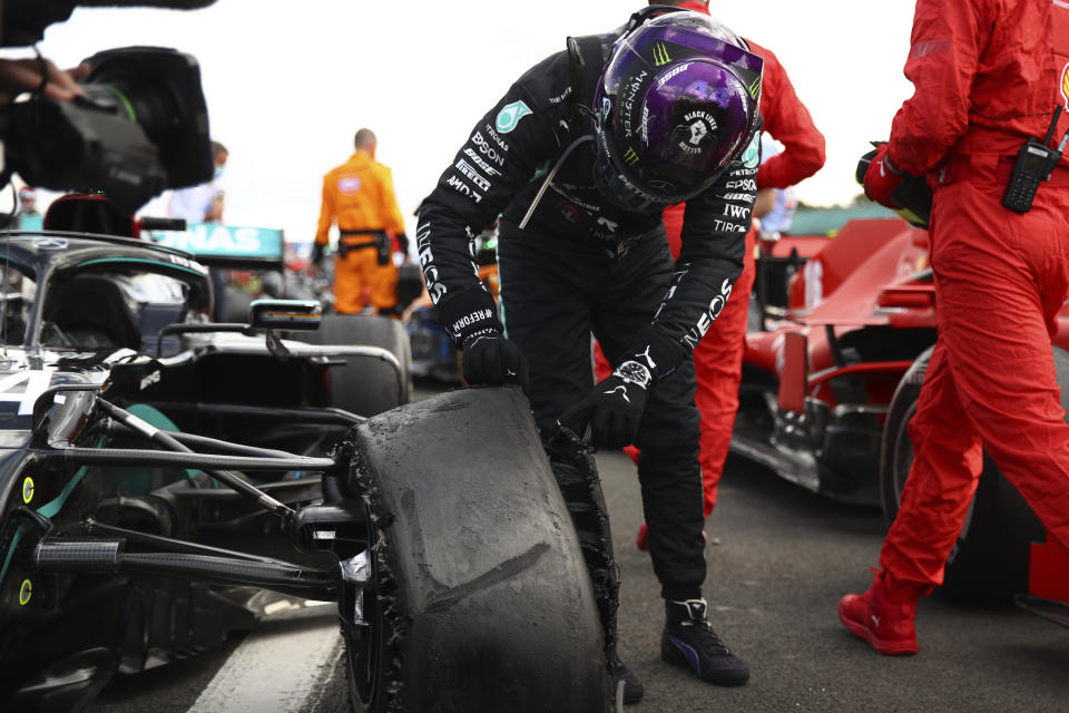 Mercedes driver Lewis Hamilton of Britain inspects puncture on his car after winning the British Formula One Grand Prix at the Silverstone racetrack, Silverstone, England, Sunday, Aug. 2, 2020. (Bryn Lennon/Pool via AP)