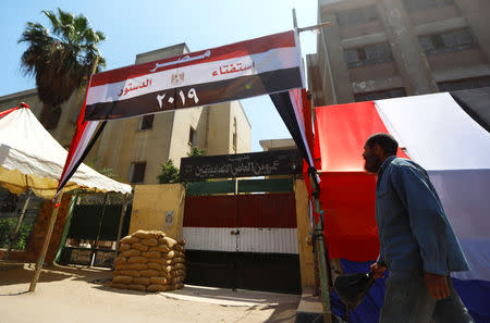 An Egyptian man walks in front of a school used as a polling station covered from outside by Egyptian flags, during the preparations for the upcoming referendum on constitutional amendments in Cairo, Egypt April 18, 2019. REUTERS/Amr Abdallah Dalsh