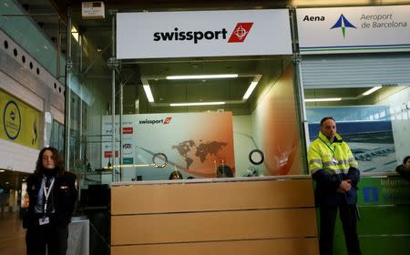 Officials stand by at the Swissport counter which handles Germanwings flights at Barcelona's El Prat airport March 24, 2015. REUTERS/Albert Gea