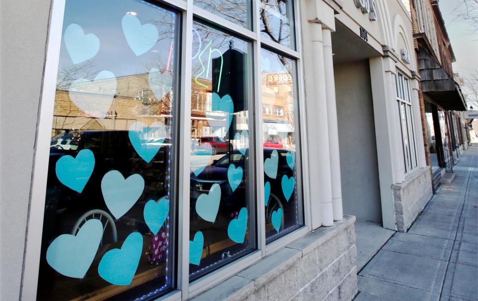 Blue hearts adorn the window at GJ’s Salon N Spa supporting missing 3-year-old Elijah Vue on Tuesday along Washington Street in Two Rivers.