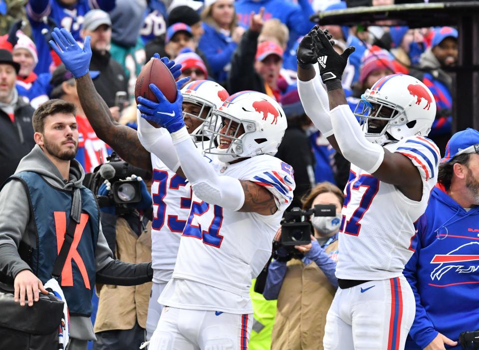 Bills safety Jordan Poyer (21) celebrates his interception against the Dolphins along with defensive back Siran Neal (33) and cornerback Tre'Davious White in 2021.
