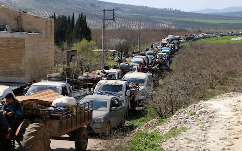 Syrian civilians ride their cars through Ain Dara in Syria's northern Afrin region as they flee Afrin city on March 12 - Credit: AFP