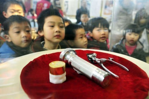 Chinese children catch a glimpse of the items used by Lei Feng as they gather at the newly opened Lei Feng memorial museum in Hangzhou, east China's Zhejiang province as part of a huge public campaign to commemorate the 50th anniversary of Lei Feng's death