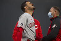 Cincinnati Reds' Eugenio Suárez, left, reacts as a trainer examines the hand on which he was hit by a pitch during the fourth inning of a baseball game against the San Francisco Giants, Monday, April 12, 2021, in San Francisco, Calif. (AP Photo/D. Ross Cameron)