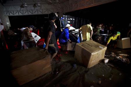 People carry looted goods as they walk through a flooded street in Acapulco September 18, 2013. REUTERS/Jacobo Garcia