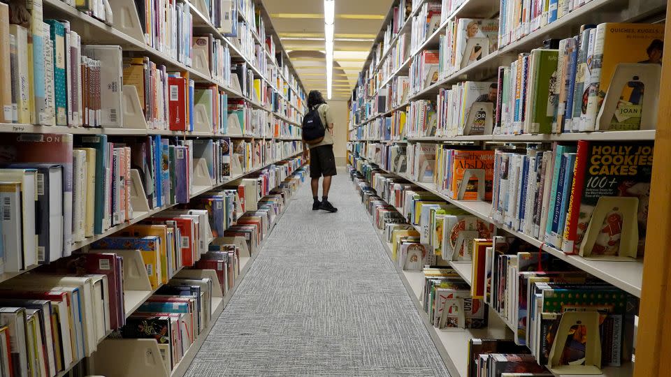 A person looks at books at a Miami-Dade Public Library on July 19, 2023 in Miami, Florida. - Joe Raedle/Getty Images