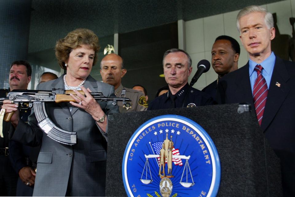 Dianne Feinstein holds an assault rifle at a press conference about banning assault weapons
