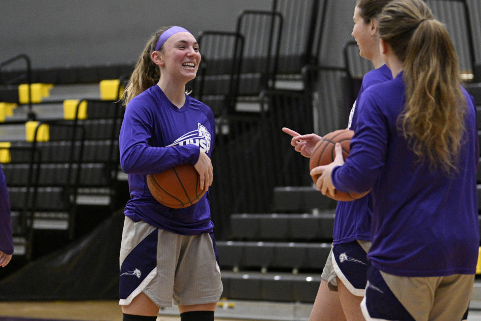 University Health Sciences and Pharmacy guard Grace Beyer laughs with teammates before an NAIA college basketball game against Cottey College Thursday, Feb. 22, 2024, in St. Louis. The eyes of the sports world have been trained on Iowa star Caitlin Clark's pursuit of women's basketball scoring history, but some have noticed that Grace Beyer at a tiny NAIA school is the only active player with more points than Clark. (AP Photo/Jeff Le)