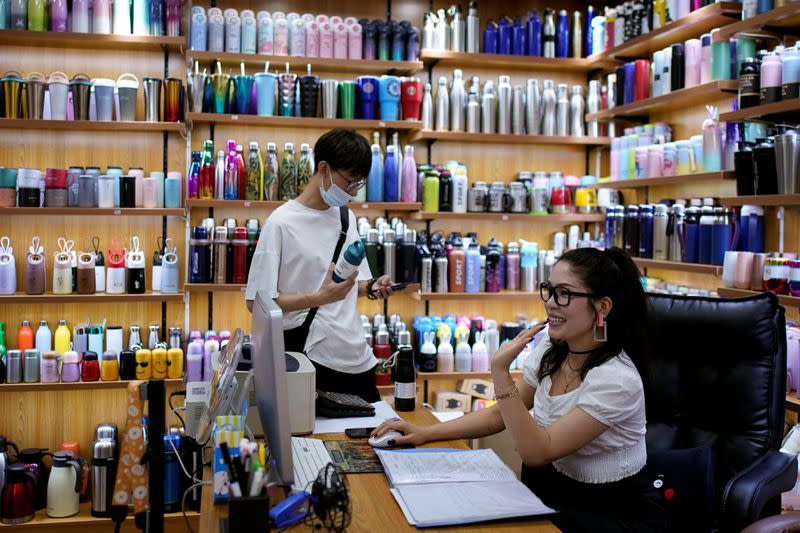 Deng Jinling, manager of Lucky Bird Trade Co. checks her online store on a company at a cup products shop at the Yiwu Wholesale Market following an outbreak of the novel coronavirus disease (COVID-19), in Yiwu