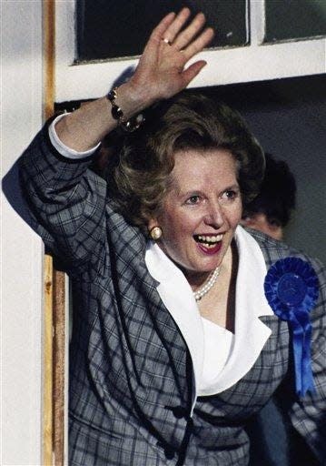 British Prime Minister Margaret Thatcher waves to supporters from a window at Conservative Party Headquarters in London, in 1987.