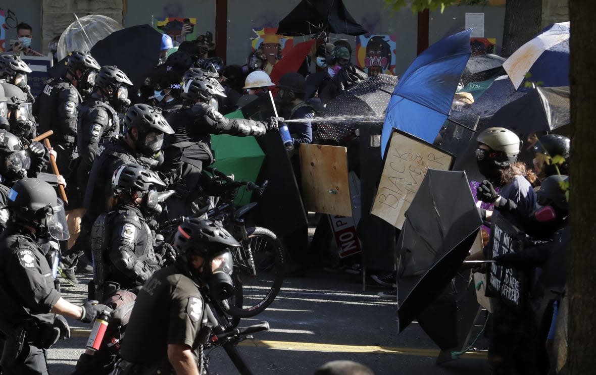 Police pepper spray Black Lives Matter protesters near Seattle Central Community College on July 25, 2020, in Seattle. (AP Photo/Ted S. Warren, File)