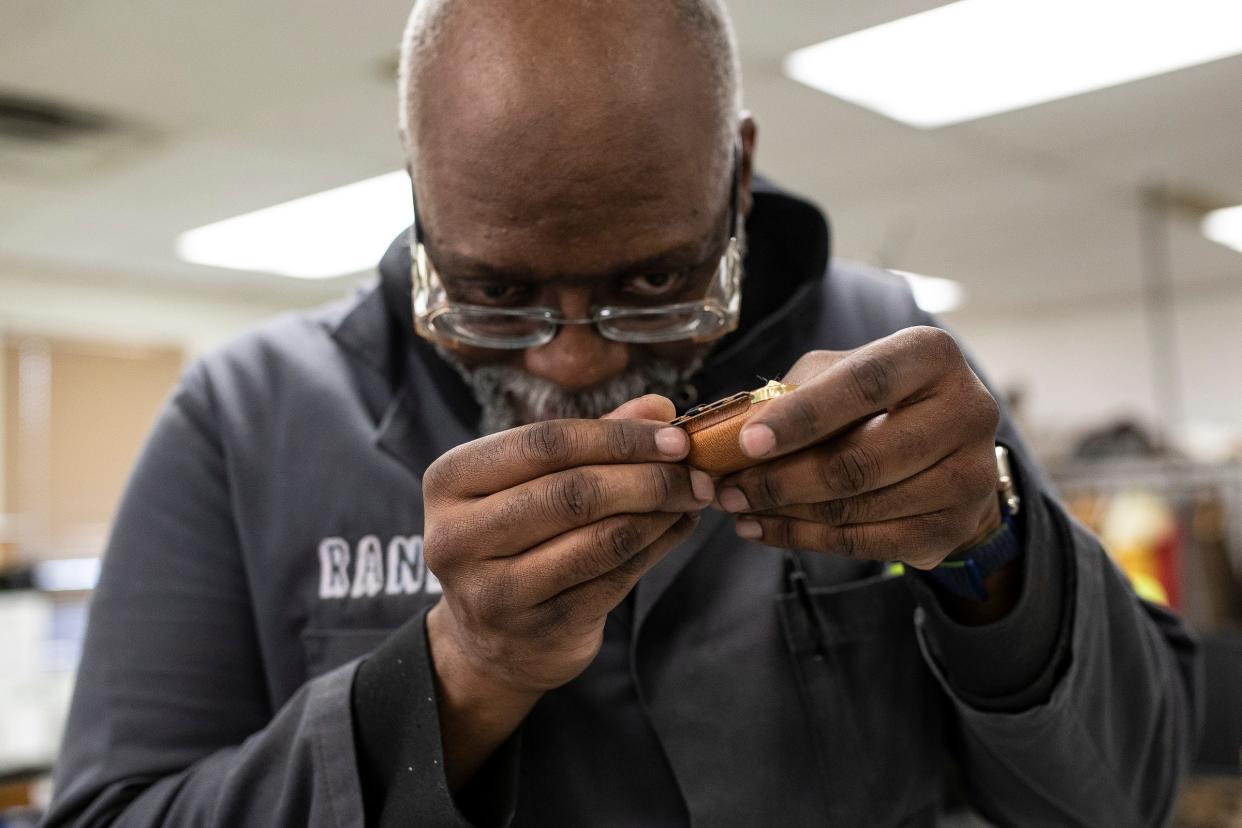 Maker Works' Randy Williams takes a close look at an alarm clock with a broken hinge during Fix-It Friday at Maker Works in Ann Arbor on Friday, April 19, 2024.