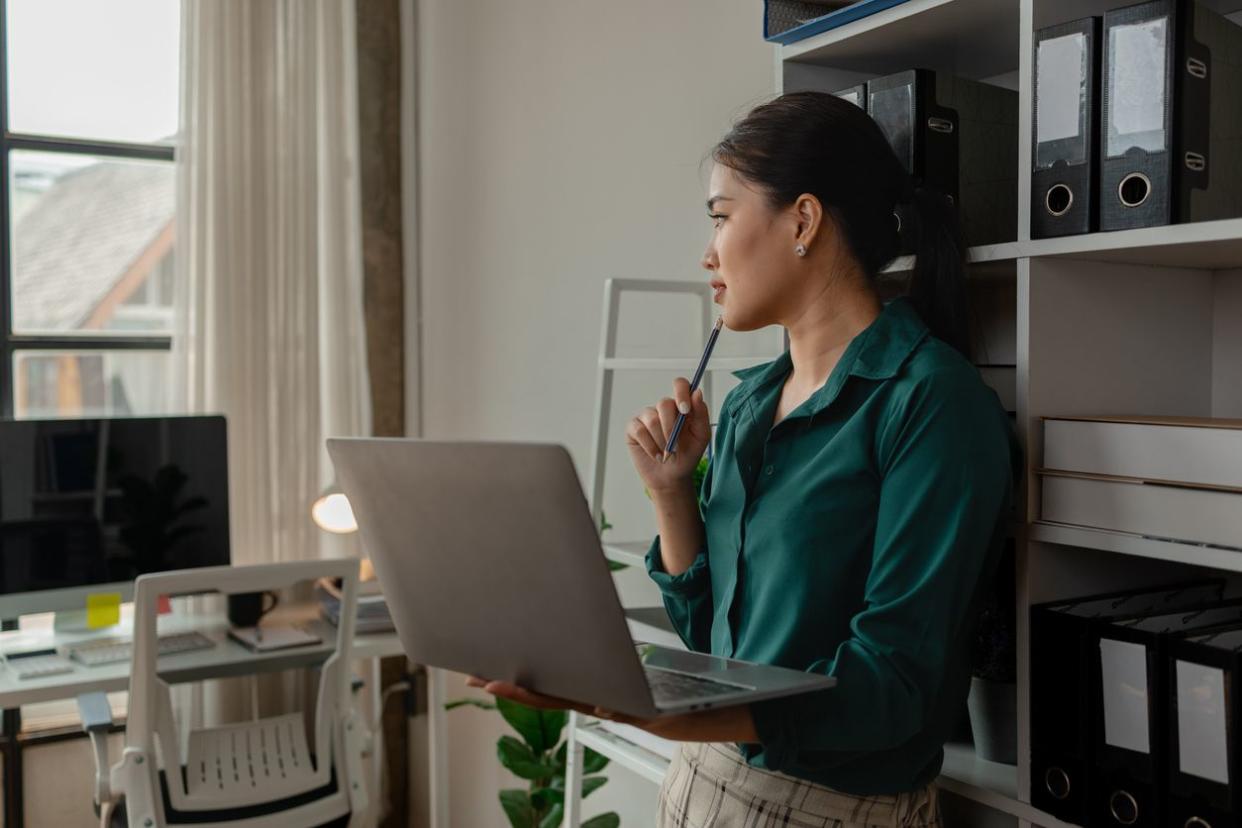 A businesswoman is using laptop in some area in workplace