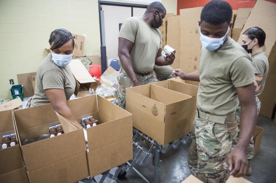 Georgia National Guard soldiers pack boxes of food at Golden Harvest Food Bank in Augusta, Ga., on a December morning.