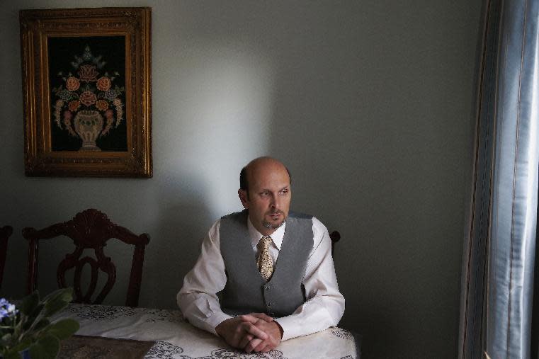 This photo taken Feb. 7, 2014 shows real estate agent Morteza Assadi, 49, in his home in Vienna, Va., Friday, Feb. 7, 2014. The Obama administration has eased the rules for would-be asylum seekers, refugees and others who hope to come to the United States or stay here and who gave ``limited” support to terrorists or terrorist groups. For Assadi, the law has left him in a sort of immigration purgatory while his green card application has been on hold for more than a decade. (AP Photo/Charles Dharapak)