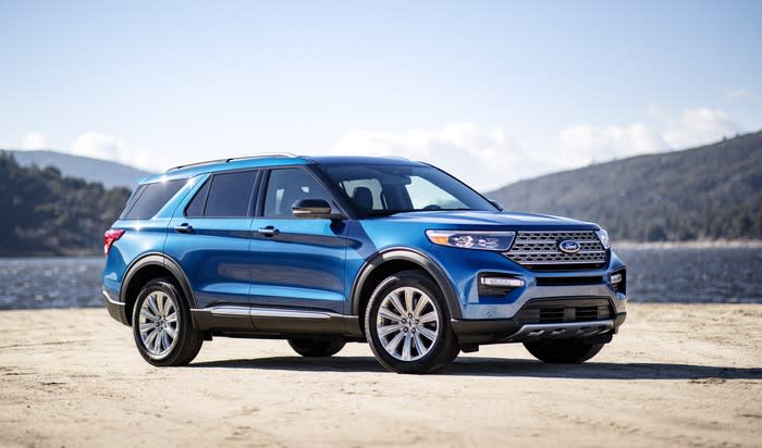 A blue 2020 Ford Explorer Hybrid, a seven-passenger crossover SUV, parked on a lakefront