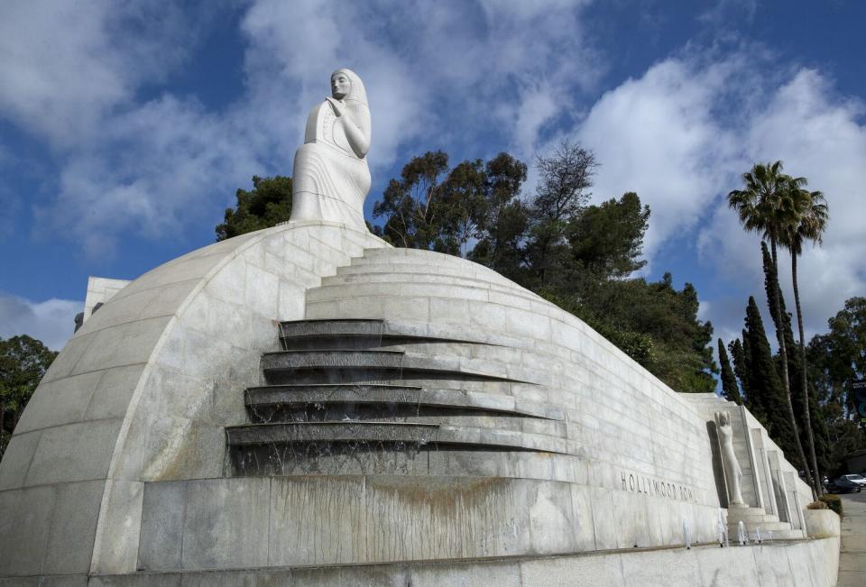 The Art Deco "Muse of Music, Dance, Drama" sculpture against a blue sky