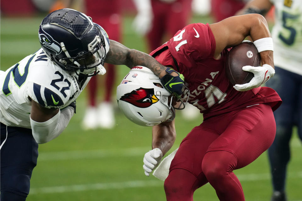 Seattle Seahawks cornerback Tre Brown (22) tries to bring down Arizona Cardinals wide receiver Michael Wilson (14) in the first half of an NFL football game Sunday, Jan. 7, 2024, in Glendale, Ariz. (AP Photo/Ross D. Franklin)