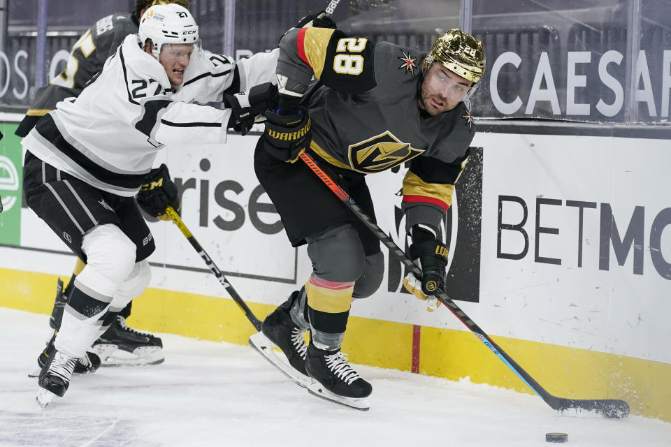 Vegas Golden Knights left wing William Carrier (28) passes around Los Angeles Kings left wing Austin Wagner (27) during the second period of an NHL hockey game Monday, March 29, 2021, in Las Vegas. (AP Photo/John Locher)