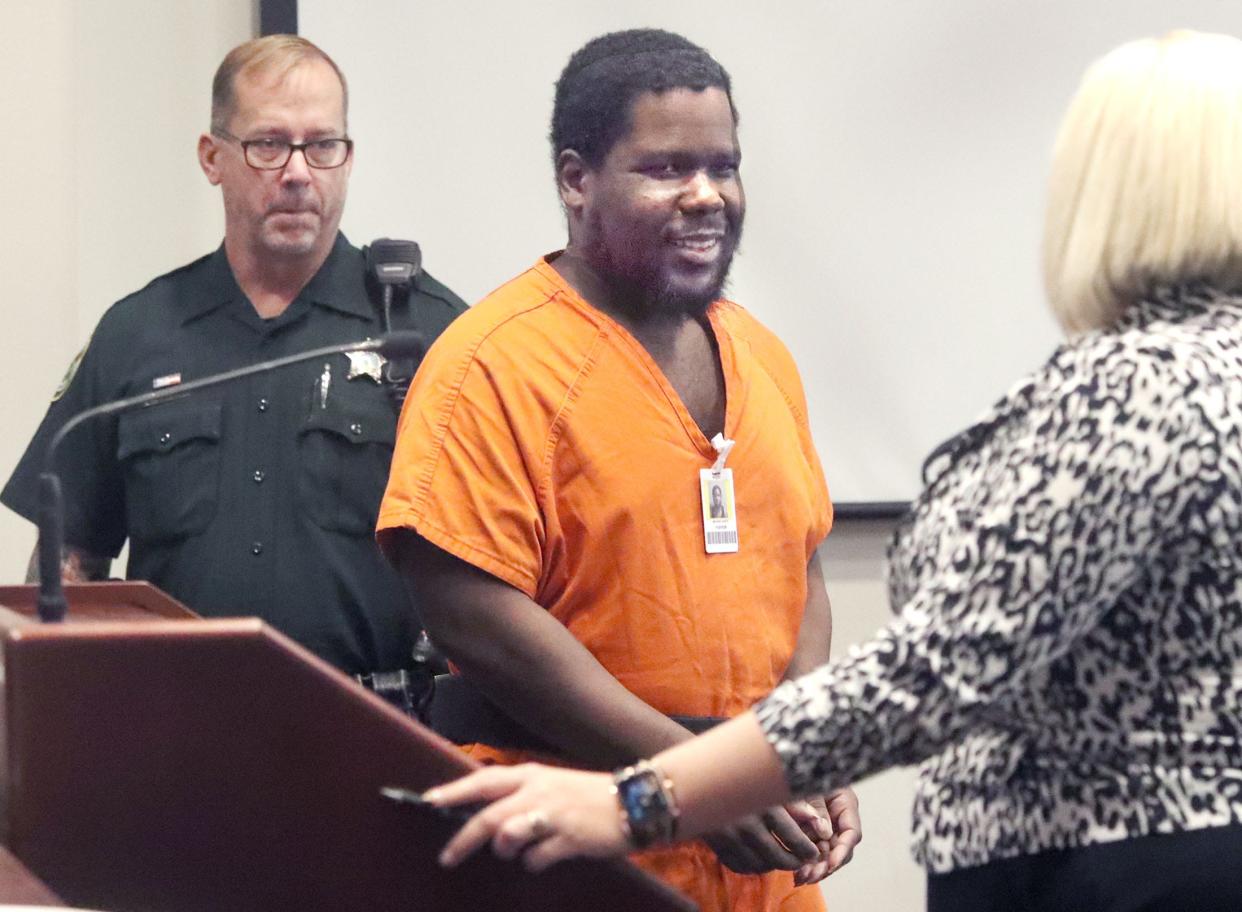 Defendant Jean Macean smiles at his attorney, Jessica Roberts, as he enters the courtroom, Friday, Nov. 18, 2022, for a hearing before Circuit Judge Elizabeth Blackburn at the S. James Foxman Justice Center in Daytona Beach.