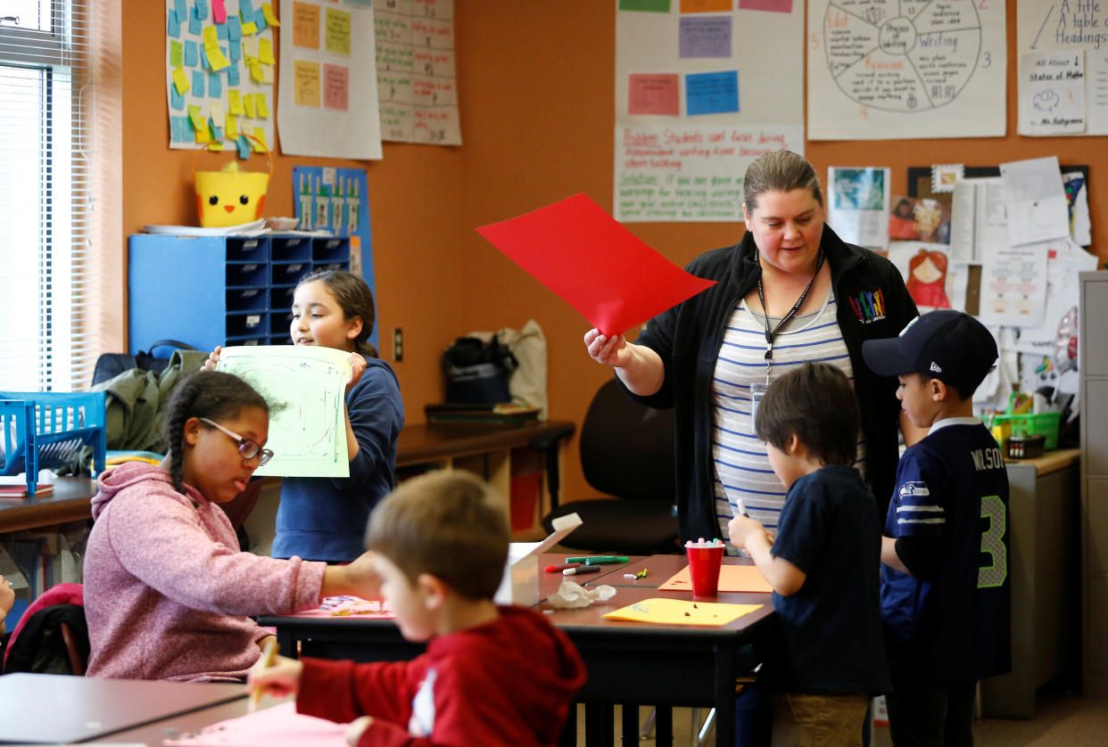 Jessie Thompson works on crafts with kids during a daycare for children of healthcare workers and first responders at Midway Elementary School during the coronavirus disease (COVID-19) outbreak in Des Moines, Washington, U.S. March 26, 2020. REUTERS/Lindsey Wasson