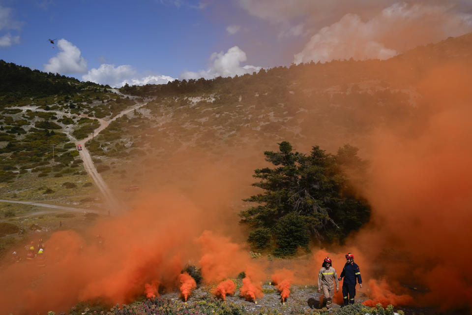 Firefighters of the 1st Wildfire Special Operation Unit and firefighters in training for the special unit, take part in a drill in Villia village some 60 kilometers (37 miles) northwest of Athens, Greece, Friday, April 19, 2024. Greece's fire season officially starts on May 1 but dozens of fires have already been put out over the past month after temperatures began hitting 30 degrees Celsius (86 degrees Fahrenheit) in late March. This year, Greece is doubling the number of firefighters in specialized units to some 1,300, adopting tactics from the United States to try and outflank fires with airborne units scrambled to build breaks in the predicted path of the flames. (AP Photo/Thanassis Stavrakis)